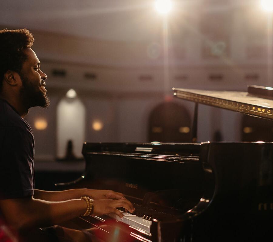 a keyboard performance major playing piano in a chapel